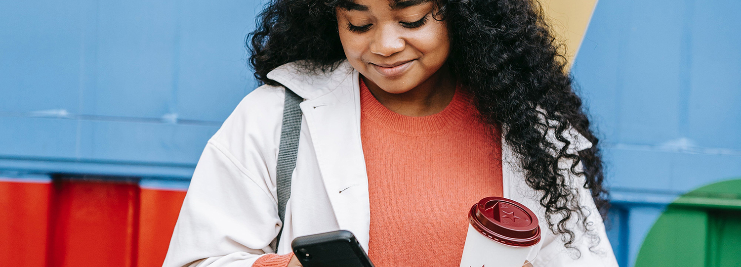 jovem com celular e copo
